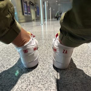 Weiße Sneaker mit den Buchstaben „IBI“ und „ZA“ auf den Fersen
